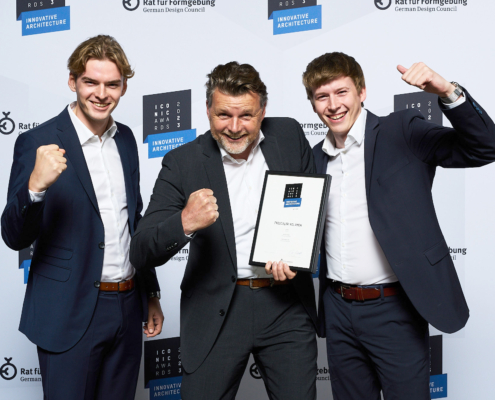 Geschäftsführer Frank Ewering und seine Söhne Ben Ewering und Max Ewering halten die Gewinnerurkunde für den ICONIC AWARD und jubeln.